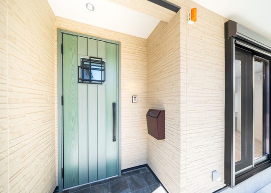 やさしい木目調のグリーンドアが印象的なエントランス